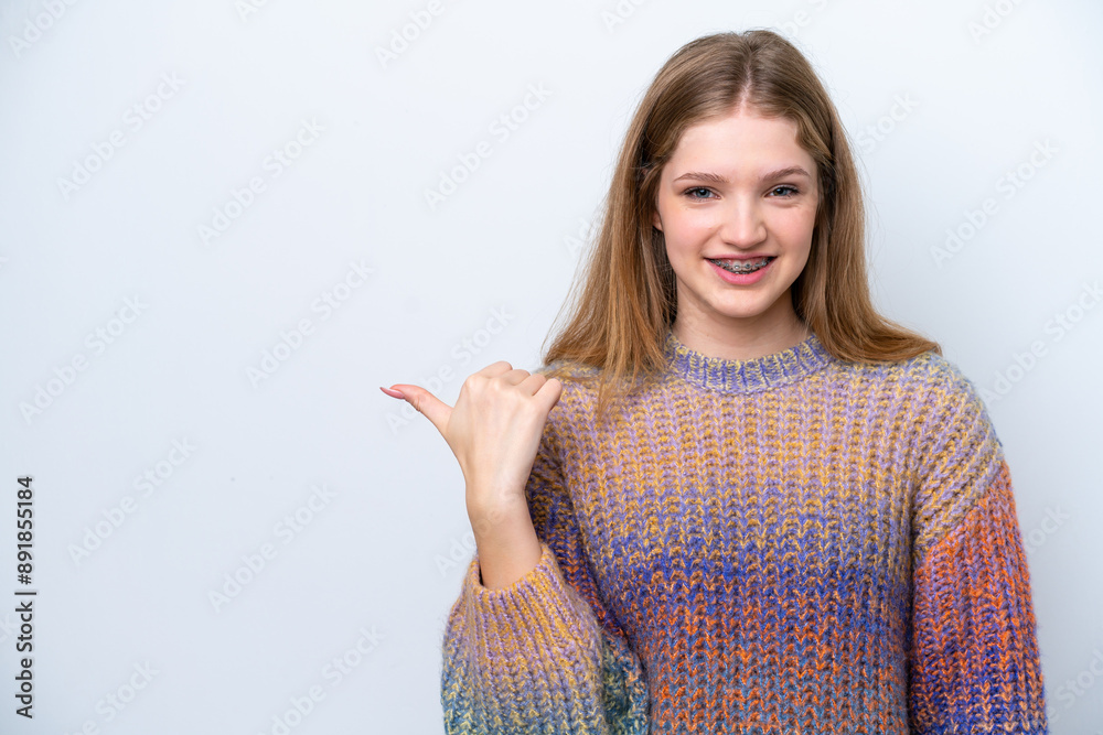 Teenager Russian girl isolated on white background pointing to the side to present a product