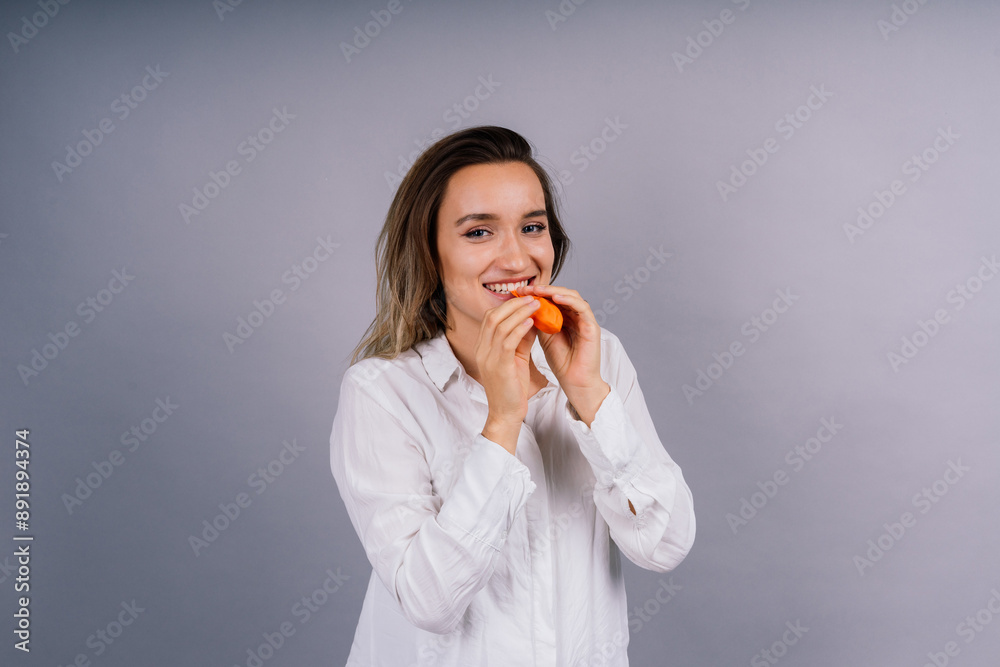 Portrait of beautiful woman with a ballon in hands on grey background in studio Portrait of beautiful woman with a ballon in hands on grey background in studio