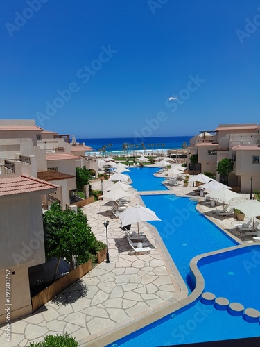 Serene poolside oasis with beach view, perfect for relaxation and vacation concepts.