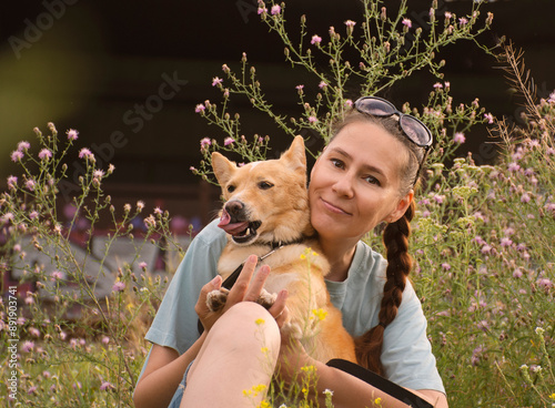 portrait of a woman hugging a dog on a walk in summer