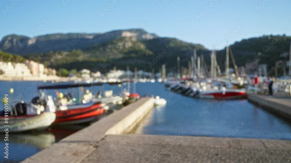 Blurred view of a busy marina with defocused boats and a picturesque mountain backdrop under a clear blue sky Blurred view of a busy marina with defocused boats and a picturesque mountain backdrop under a clear blue sky