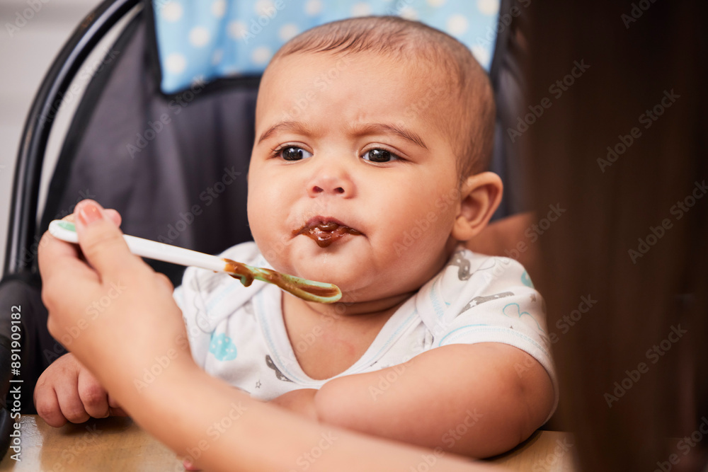 Mom, taste and face of baby with spoon, food and health for growth, child development and breakfast in high chair. Diet, nutrition and infant at table with woman for morning eating schedule in home Mom, taste and face of baby with spoon, food and health for growth, child development and breakfast in high chair. Diet, nutrition and infant at table with woman for morning eating schedule in home