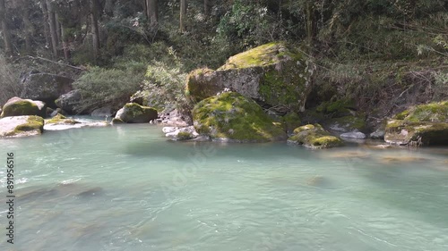 日本の風景 温泉のような色をした、緑白濁色の川がながれる渓谷 苔むした大きな岩を空撮