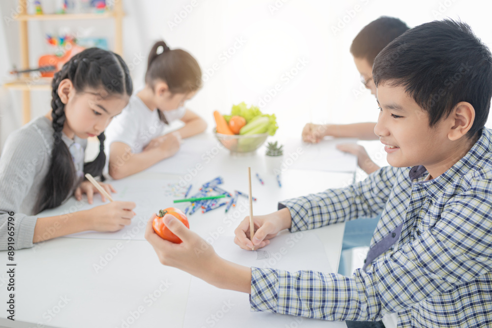 Asian boy use hand holding tomato, asian children group training to drawing and paint image, they feeling happy and smile, they use pencil and crayon color in art training time Asian boy use hand holding tomato, asian children group training to drawing and paint image, they feeling happy and smile, they use pencil and crayon color in art training time