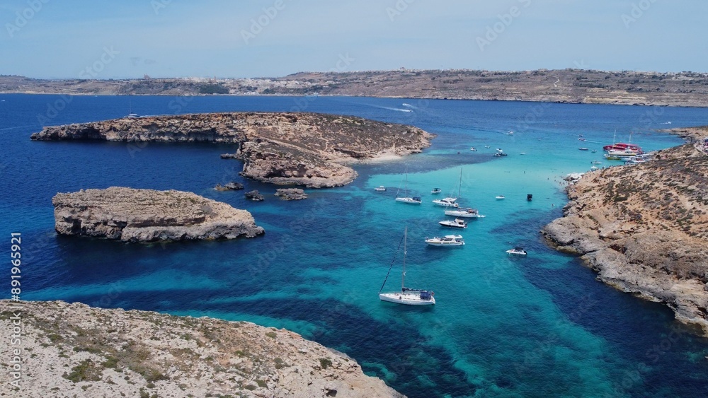 Boats floating in the crystal clear turquoise sea water. Blue lagoon, Comino, Maltese Islands. Aerial establishing view. High quality photo Boats floating in the crystal clear turquoise sea water. Blue lagoon, Comino, Maltese Islands. Aerial establishing view. High quality photo