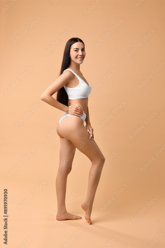 Smiling woman with perfect skin in underwear posing on beige background. Body care Smiling woman with perfect skin in underwear posing on beige background. Body care