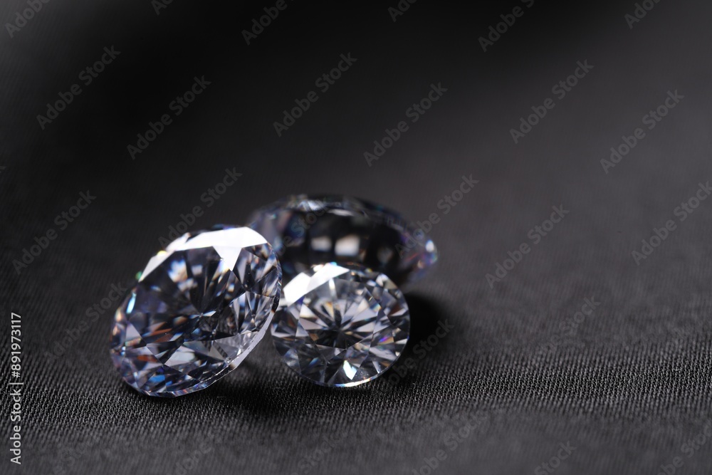 Many beautiful shiny diamonds on black fabric, closeup Many beautiful shiny diamonds on black fabric, closeup