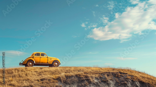 yellow vintage car on hill with blue sky background