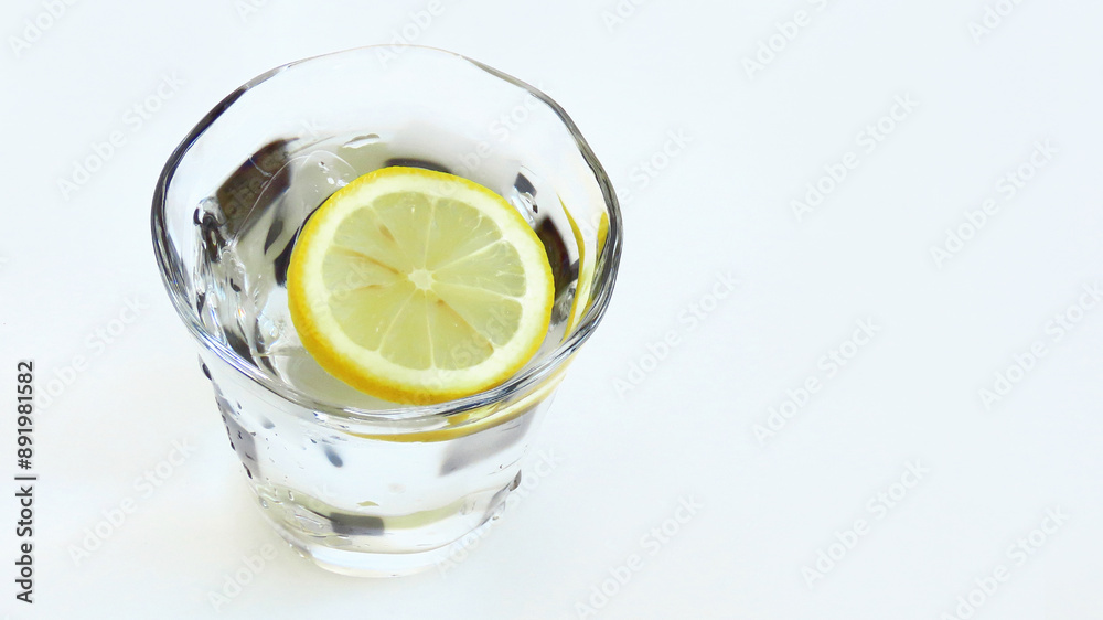 Glass of cold ice water with a salted lemon slice for vitamin mineral supplementation Glass of cold ice water with a salted lemon slice for vitamin mineral supplementation