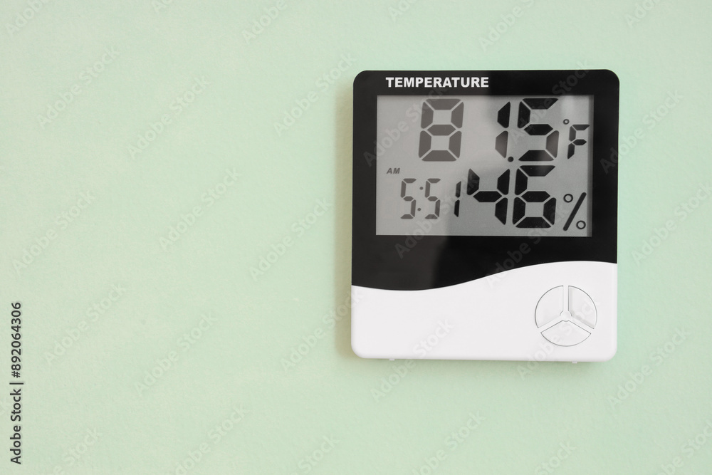 Digital hygrometer on light green wall Digital hygrometer on light green wall