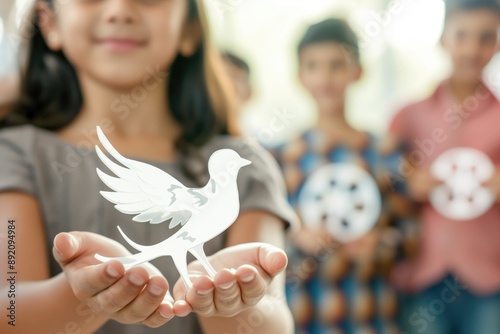 Children holding paper cutouts of dove, peace sign, and recycle symbol, showcasing sustainability concepts. Peace education, environmental awareness, recycling, social unity, childhood learning. photo