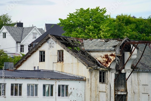 View of old buildings in Gomalandet surrounded by green trees. Kristiansund, Norway photo