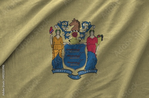 New Jersey US state flag depicted on folded wavy fabric of old cloth close up