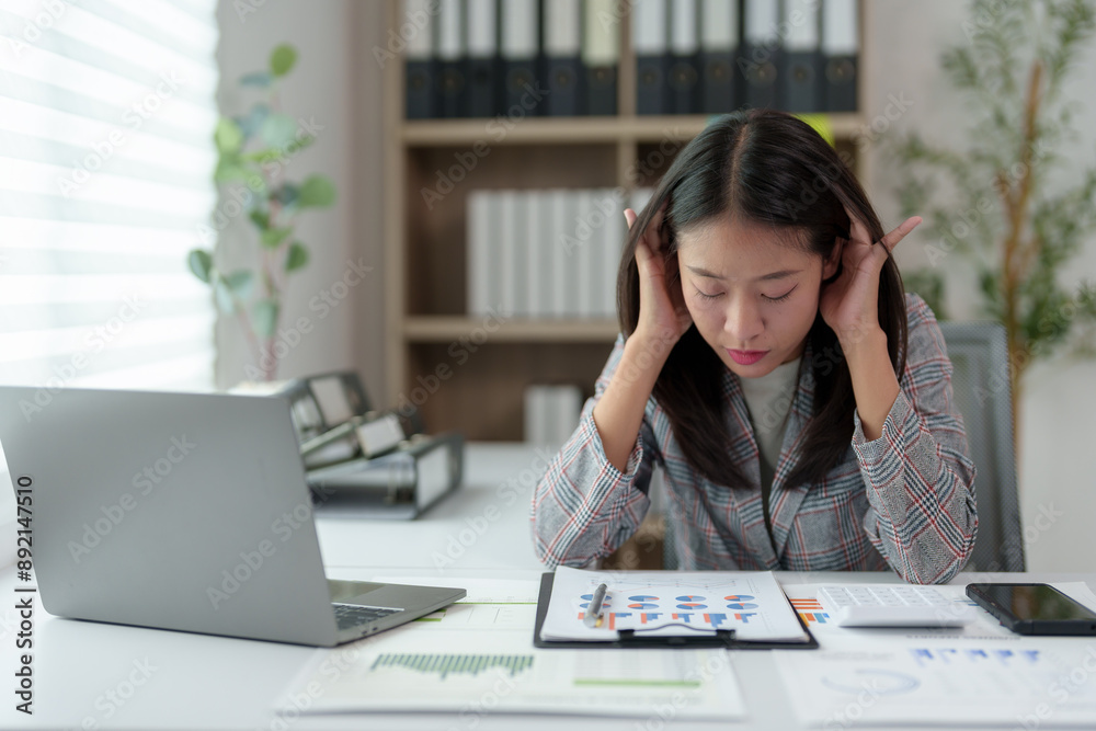 Stressed Asian woman while working on PC computer Tired Asian businesswoman with headache Stressed out at the office feeling sick at work Office syndrome concept. Stressed Asian woman while working on PC computer Tired Asian businesswoman with headache Stressed out at the office feeling sick at work Office syndrome concept.