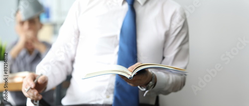 Businessman in white shirt with blueu tie hold diary in hand closeup. Business education concept photo