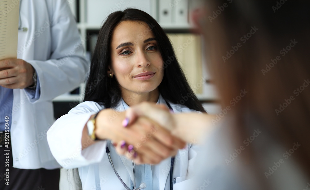 Beautiful smiling female GP shaking hands with visitor portrait. Self introduction cheering and support or problem solution deal concept Beautiful smiling female GP shaking hands with visitor portrait. Self introduction cheering and support or problem solution deal concept