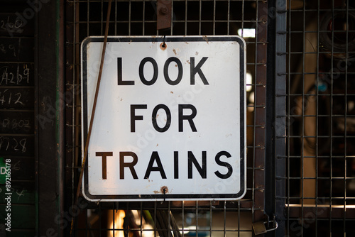 look for trains black and white sign warning old station