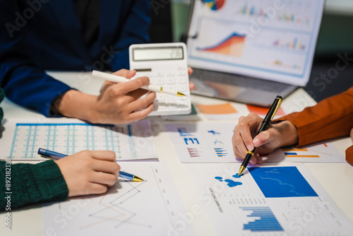 Close-up of hands working on UX/UI design at a desk. Papers with wireframes, prototypes, and mockups detail user flows, personas, and A/B testing, ensuring usability and responsive design.