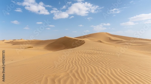 Golden sand dunes under a blue sky with few clouds.