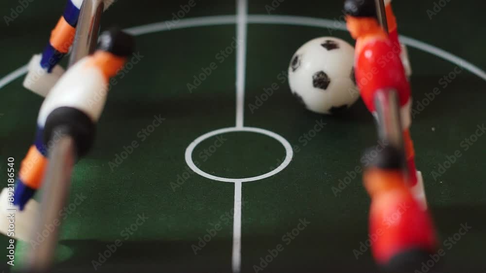 close-up table football players move on the playing field, play with the ball, slow motion. board sports games concept