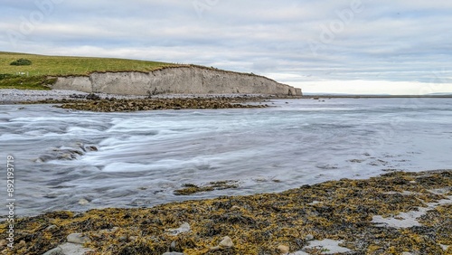 Obraz na płótnie Dramatic coastal sunset landscape scenery with cliffs in background, sandy Silverstrand beach, Galway, Ireland, nature wallpaper w salonie