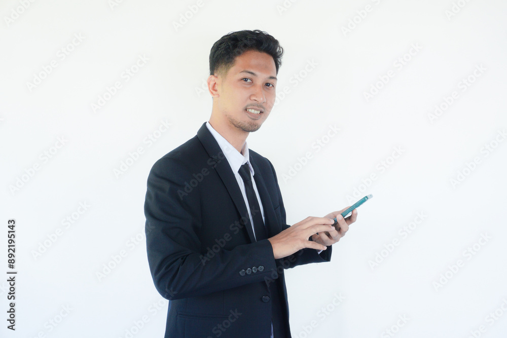 Asian businessman smiling while pointing to mobile phone that he hold Asian businessman smiling while pointing to mobile phone that he hold