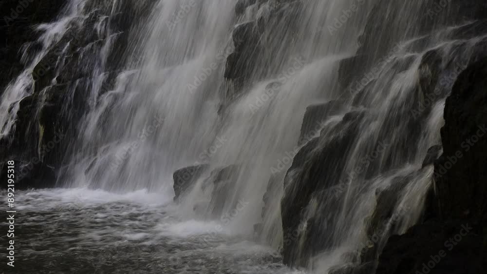 cascade du Pont à Cheylade avec eau coulant sur des roches volcaniques sombres