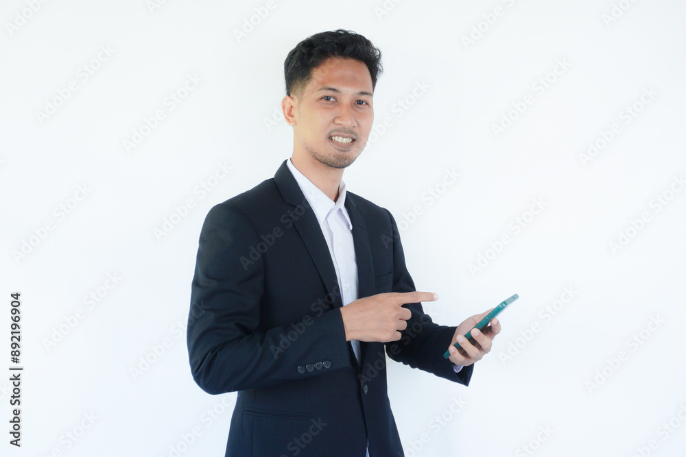 Asian businessman smiling while pointing to mobile phone that he hold Asian businessman smiling while pointing to mobile phone that he hold