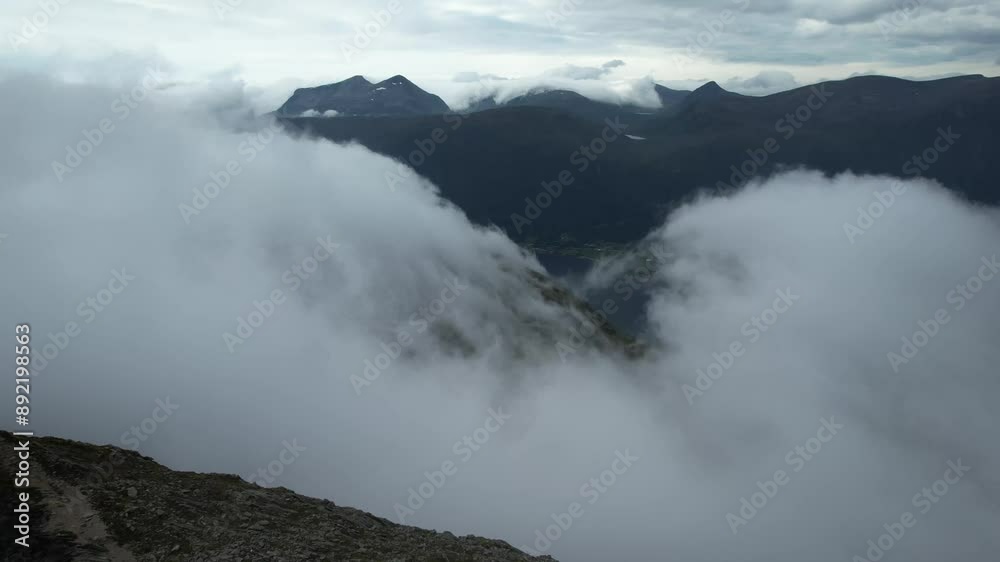 drone aerial view over Andalsnes and Romsdalseggen mountains in summer with fog covering the summits in Norway Romsdalen and Romsdalseggen Ridge drone aerial view over Andalsnes and Romsdalseggen mountains in summer with fog covering the summits in Norway Romsdalen and Romsdalseggen Ridge