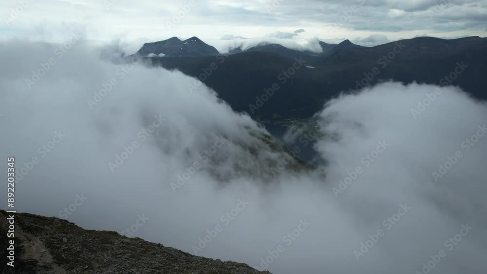 drone aerial view over Andalsnes and Romsdalseggen mountains in summer with fog covering the summits in Norway Romsdalen and Romsdalseggen Ridge drone aerial view over Andalsnes and Romsdalseggen mountains in summer with fog covering the summits in Norway Romsdalen and Romsdalseggen Ridge