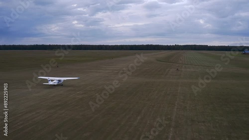 A light-engine airplane takes off in a field.