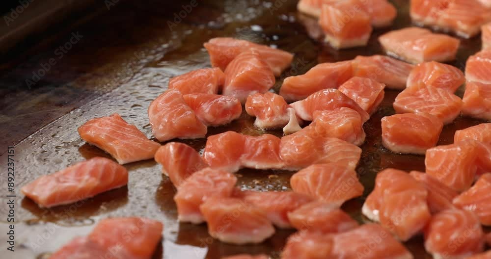 Small pieces of red fish in sizzling oil in a pan. Cooking fish. Salmon. Small pieces of red fish in sizzling oil in a pan. Cooking fish. Salmon.