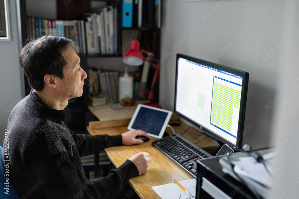 Man working on laptop at home, bar charts displaying on the computer screen. Man working on laptop at home, bar charts displaying on the computer screen.