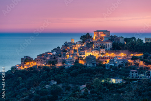 Fototapeta Naklejka Na Ścianę i Meble -  Panoramic view of Castellabate illuminated in the evening with the sea in the background. Cilento, Campania, southern Italy.