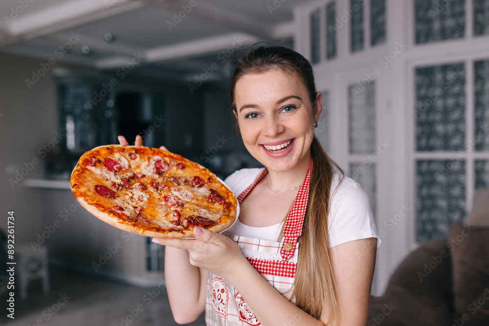 happy young woman in apron hold pizza in the kitchen smiling happy young woman in apron hold pizza in the kitchen smiling