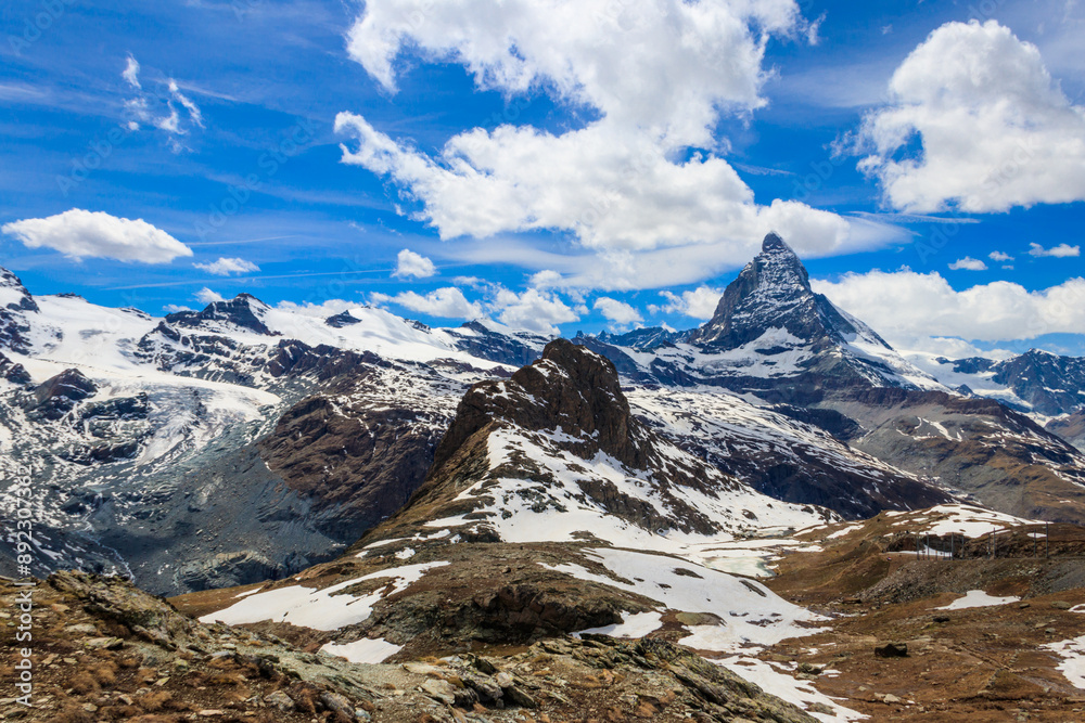Scenic view on snowy Matterhorn mountain peak in sunny day with blue sky in Switzerland. Beautiful nature background of Swiss Alps covered with snow. Famous travel destination Scenic view on snowy Matterhorn mountain peak in sunny day with blue sky in Switzerland. Beautiful nature background of Swiss Alps covered with snow. Famous travel destination