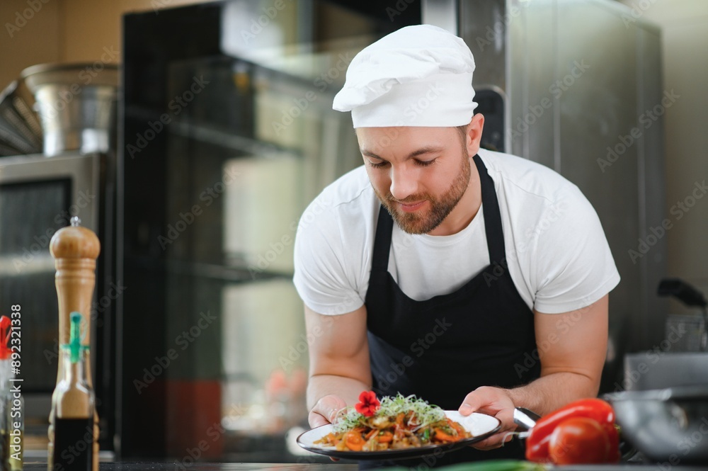 Portrait of handsome positive chef cook at the restaurant kitchen Portrait of handsome positive chef cook at the restaurant kitchen