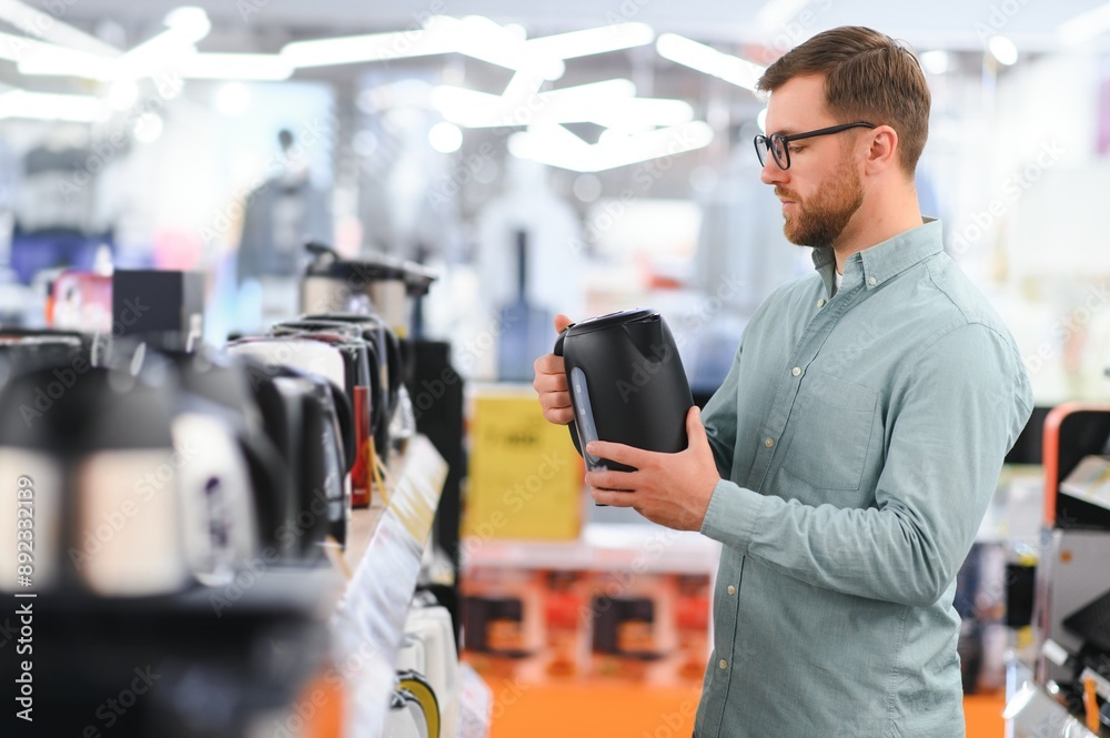 Man choosing electric kettle at store Man choosing electric kettle at store