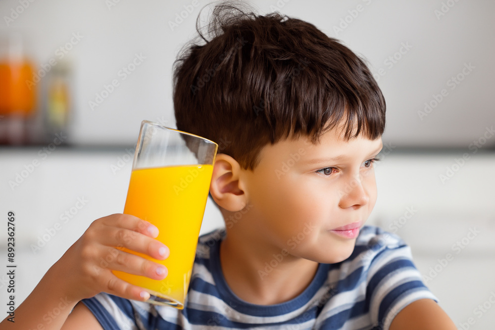 A boy is having breakfast with oranges and juice. Child drink family concept. A boy is drinking orange juice. A boy is having breakfast with oranges lifestyle and drinking juice. A boy is having breakfast with oranges and juice. Child drink family concept. A boy is drinking orange juice. A boy is having breakfast with oranges lifestyle and drinking juice.
