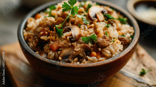 Close-up to a bowl of sizzling tasty rice with sliced mushrooms and greens in a rural bowl