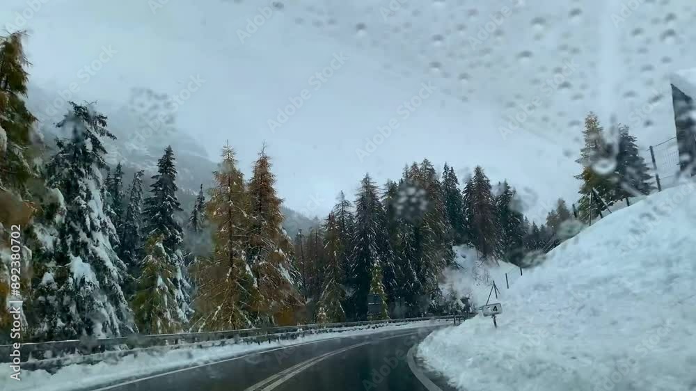 Winter road through snow-covered mountains and trees, passing by a snowplow and a rustic wooden bar Winter road through snow-covered mountains and trees, passing by a snowplow and a rustic wooden bar
