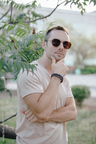 Fashion portrait of man near tree with bracelet