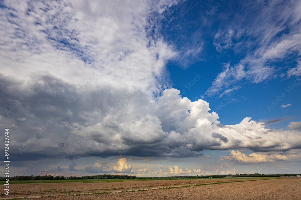 Fototapeta premium A cloudy sky with a few clouds in the distance