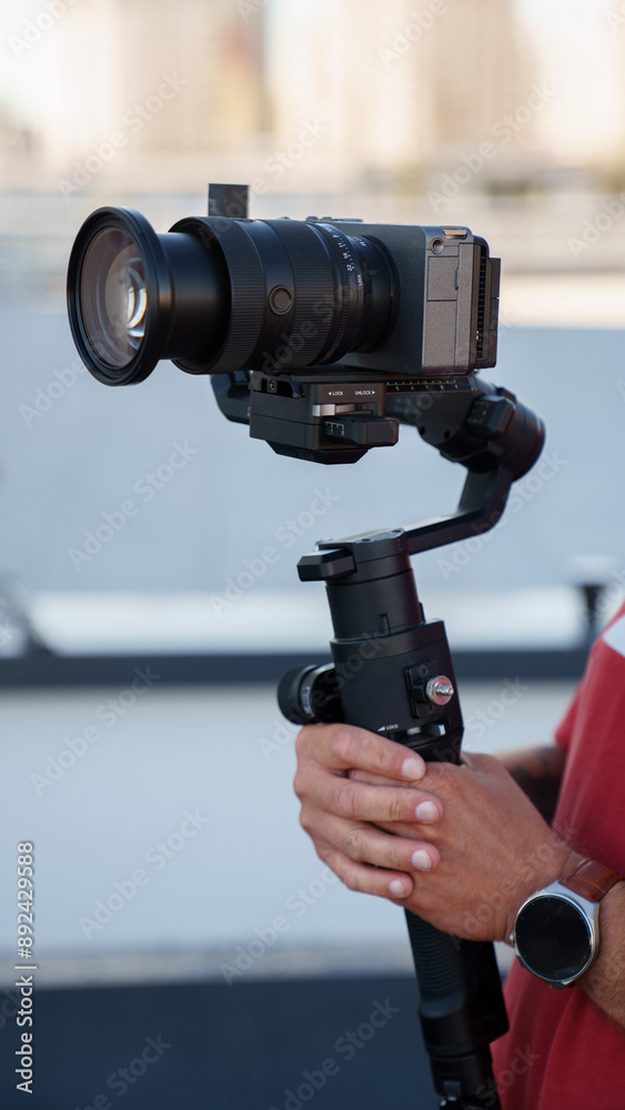 Vertical close-up photo of gimbal stabilizer and modern mirrorless camera. Video production concept Vertical close-up photo of gimbal stabilizer and modern mirrorless camera. Video production concept