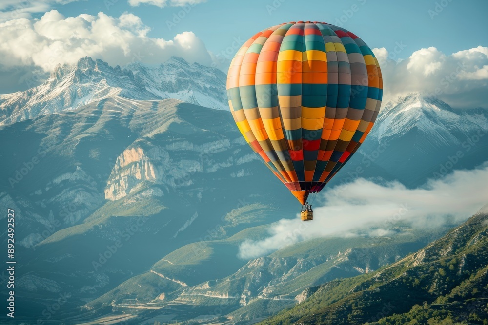 Fototapeta premium A colorful hot air balloon floats above a majestic mountain range