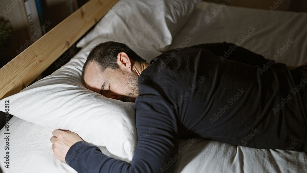 A bearded man sleeping peacefully in a dimly lit bedroom at night, portraying a serene home atmosphere. A bearded man sleeping peacefully in a dimly lit bedroom at night, portraying a serene home atmosphere.