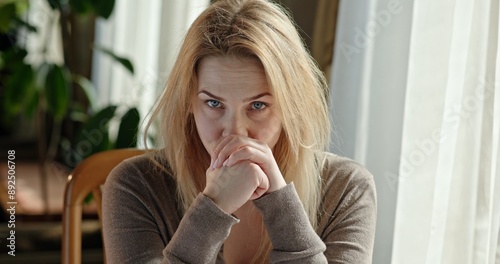 Photos Anxious distressed woman rocking to a fro in a chair looking from side to side and wringing her hands together
