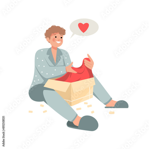 Young man packing or unpacking belongings in cardboard box