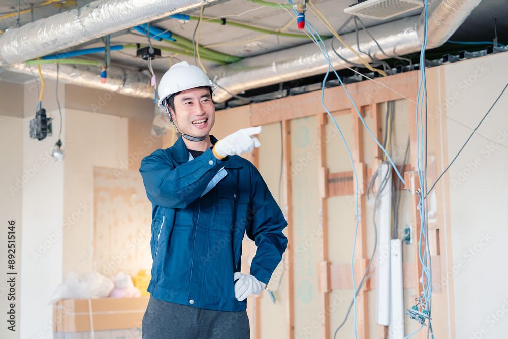 指差しをして安全確認をする男性の建築作業員 指差しをして安全確認をする男性の建築作業員