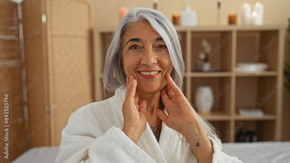 Woman enjoying relaxation at a spa wearing a white robe, in a peaceful wellness room, featuring a warm interior with candles, focusing on a middle-aged beautiful woman with grey hair Woman enjoying relaxation at a spa wearing a white robe, in a peaceful wellness room, featuring a warm interior with candles, focusing on a middle-aged beautiful woman with grey hair